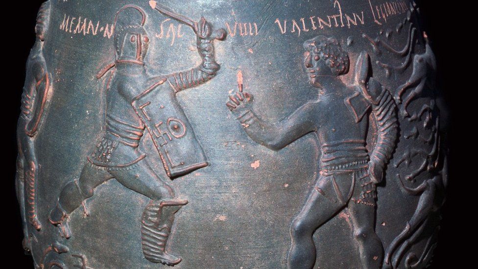 Closeup of a frieze on an ancient pot which depicts a pair of gladiators