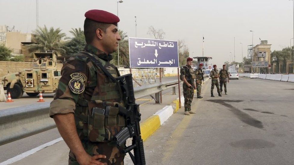 Iraqi security forces stand guard as they check motorists entering the heavily fortified Green Zone in Baghdad (05 October 2015)