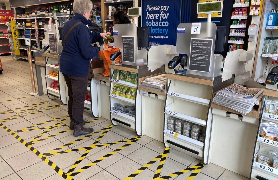 Taped-off areas for customers distance themselves from each other are seen at the checkout till area of a local Tesco store as the number of coronavirus disease cases (COVID-19) grow around the world, in London, Britain, March 21, 2020. REUTERS/Toby Melville