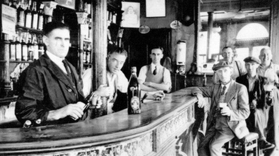Patrick McGurk (third from left) pictured behind the bar of his family pub