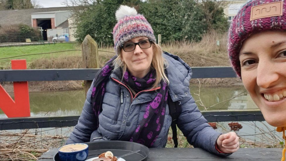 Laura sat at a picnic table with her friend Mo