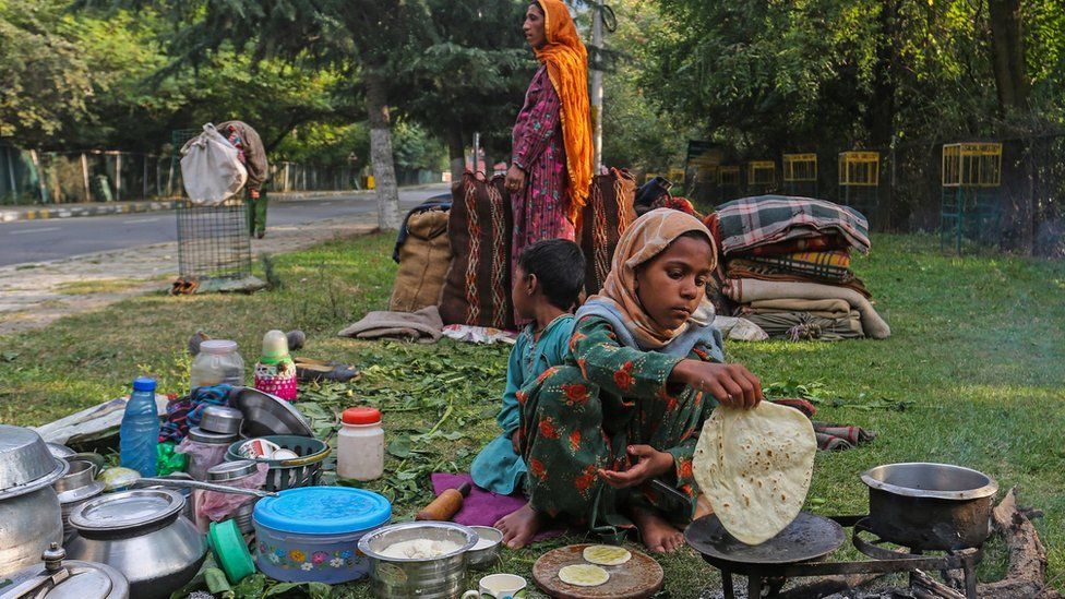 A Bekarwal nomad community girl prepares bread for her family members at a roadside temporary camp in Srinagar.