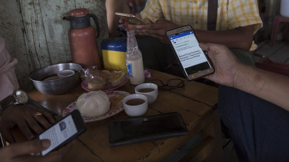 Customers in a cafe in Myanmar using Facebook