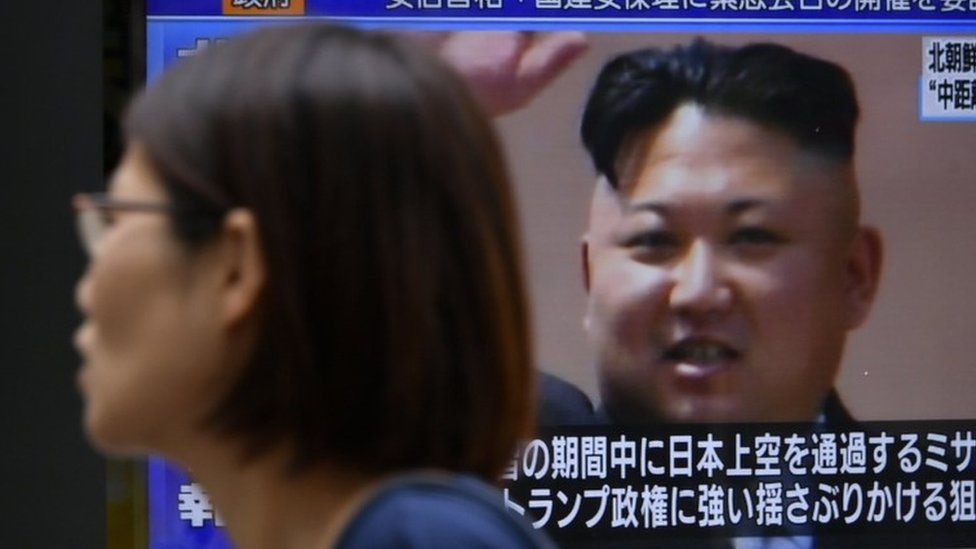 A pedestrian walks past a TV screen on a street displaying North Korean leader Kim Jong-un after North Korea"s missile launch, in Tokyo, Japan, 29 August 2017