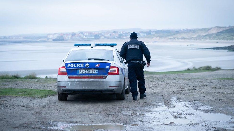 File photo of a French Police officer looking out over a beach near Wimereux in France