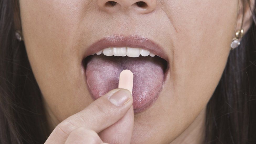 Close up of woman swallowing pill