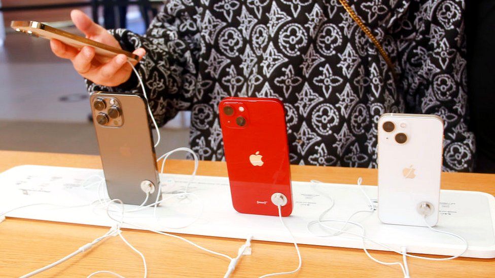 Женщина смотрит на Apple iPhones