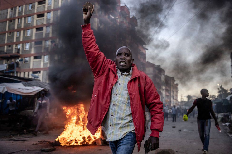 An opposition supporter holds a stone during clashes with Kenya Police Officers at the informal settlement of Mathare in Nairobi, Kenya - Monday 27 March 2023