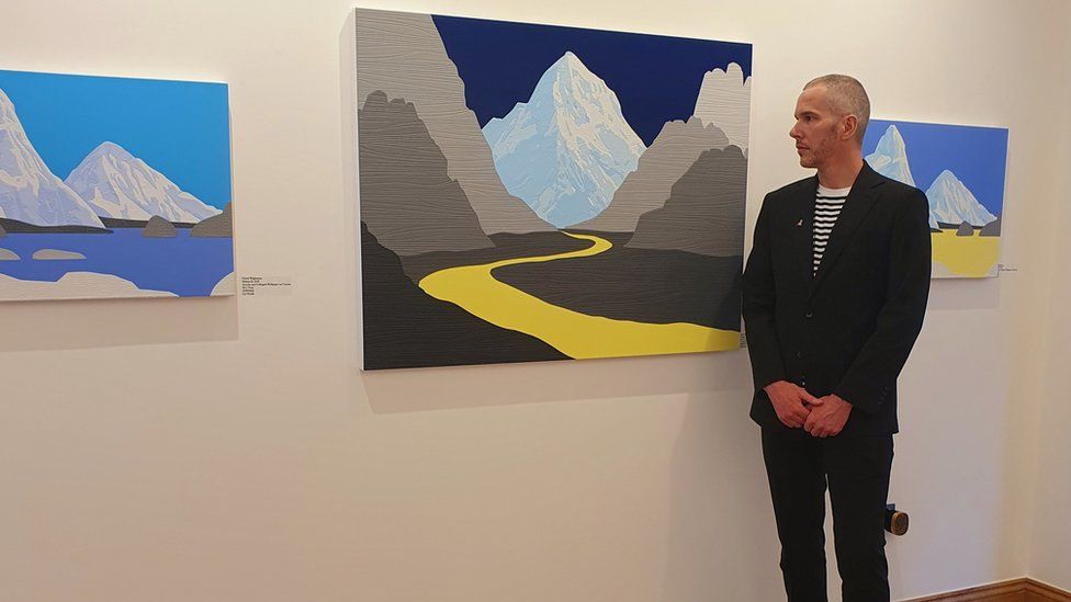 David Wightman stood beside his artworks