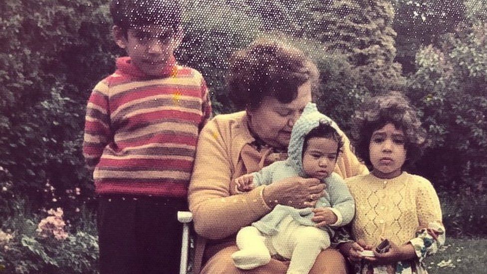 Sharon as a baby sitting on her paternal grandmother's knee with her brother and sister