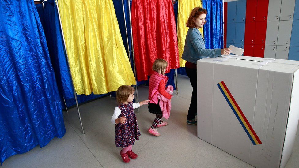 A woman is followed by her daughters while casting her ballot during the family re-definition referendum at a polling station in Bucharest, Romania, 07 October 2018.