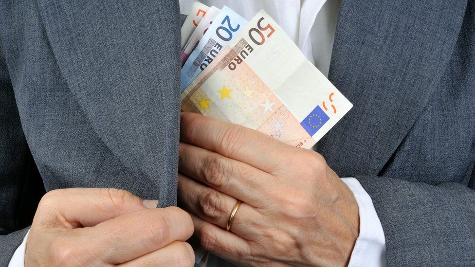 Человек кладет евро в карман