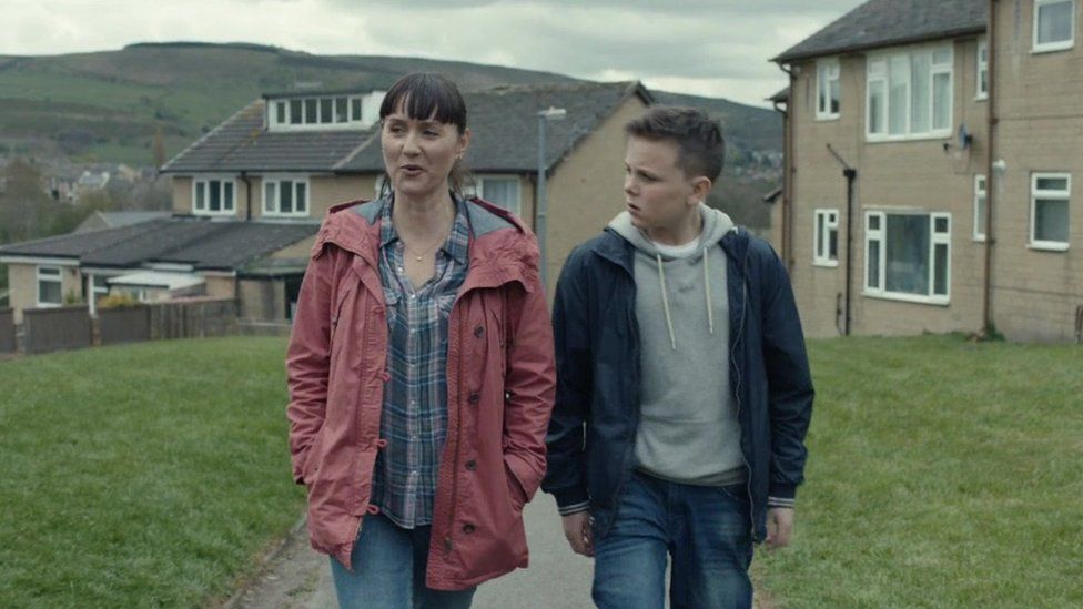 still from advert showing mother and son walking
