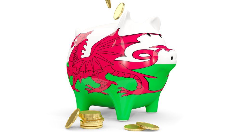 Piggy bank with flag of wales and money isolated on white