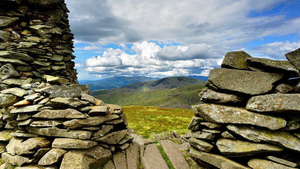 A stone cairn with hills beyond