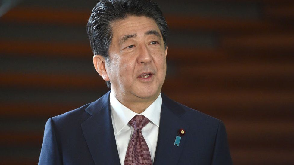 Japan's outgoing Prime Minister Shinzo Abe speaks to the media upon his arrival at his office in Tokyo on September 16, 2020.