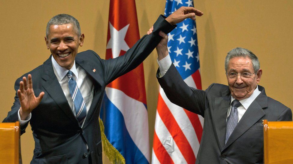 На этом архивном фото от 21 марта 2016 года президент Кубы Рауль Кастро (справа) поднимает руку президента Барака Обамы по завершении их совместной пресс-конференции во Дворце Революции в Гаване, Куба