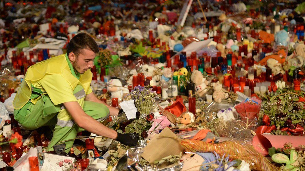 A municipal worker removes flowers from a tribute in memory of the victims of the Las Ramblas attack, Barcelona, 28 August 2017