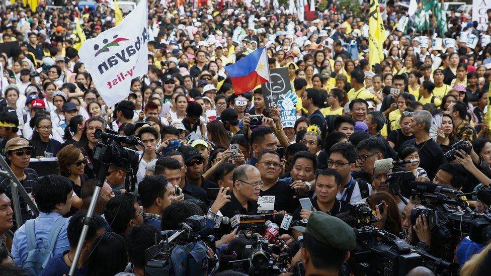 Former Filipino President Benigno Aquino, centre, speaks to media as he joins demonstration to mark 31st anniversary of the People Power Revolution in Quezon City, east of Manila, Philippines. 25 February 2017