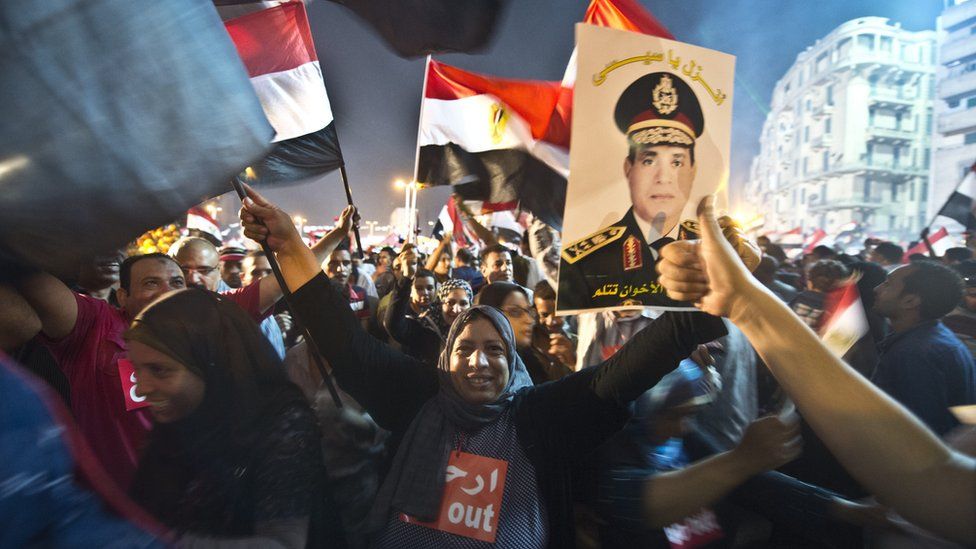 People celebrate in Cairo's Tahrir Square with a portrait of Abdul Fattah al-Sisi after the overthrow of President Mohammed Morsi on 3 July 2013
