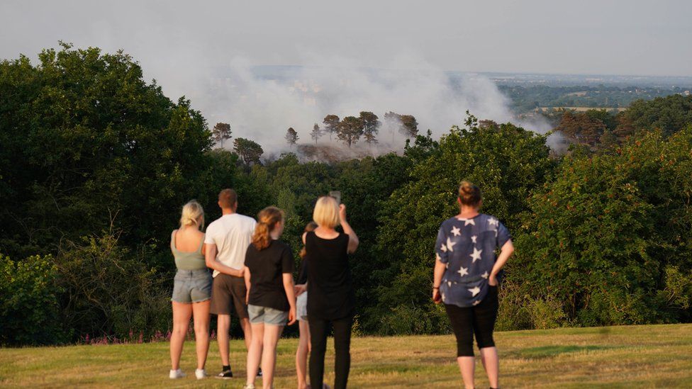 People watch smoke rise at Lickey Hills Country Park near Birmingham
