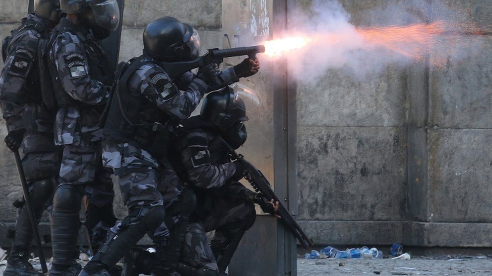 Police fire towards protesters during a protest against proposed austerity measures on 6 December 2016 in Rio de Janeiro, Brazil