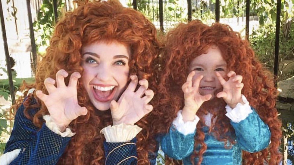 A mother and daughter dressed as matching Disney princesses