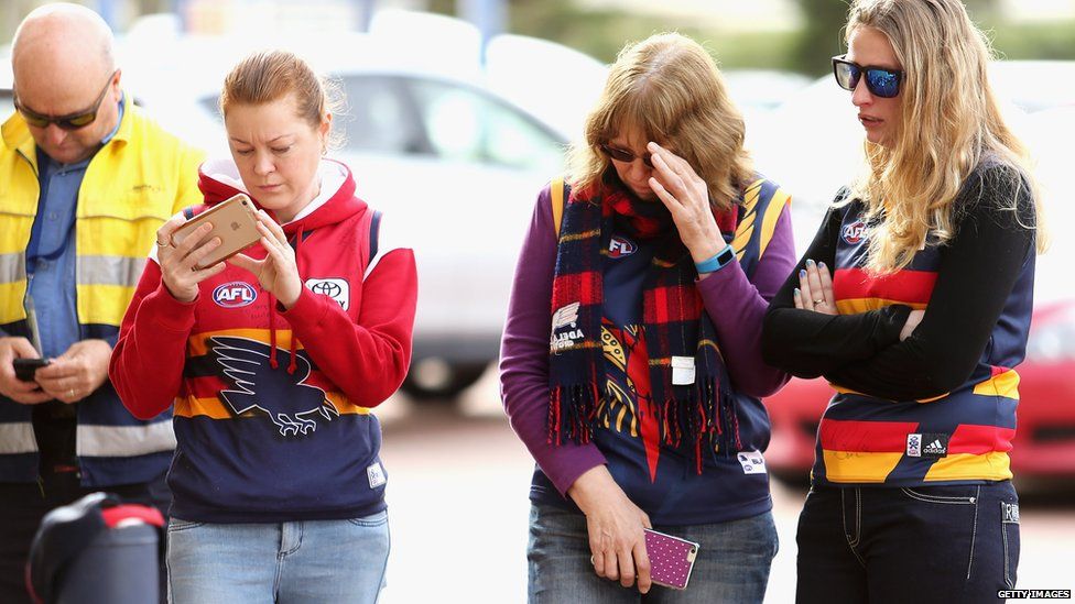 Adelaide Crows fans gather outside the AAMI Stadium in Adelaide, South Australia after Phil Walsh's death, 3 July 2015
