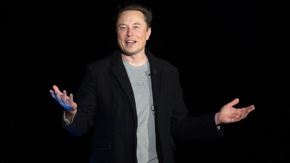 Elon Musk presents on stage at a SpaceX event