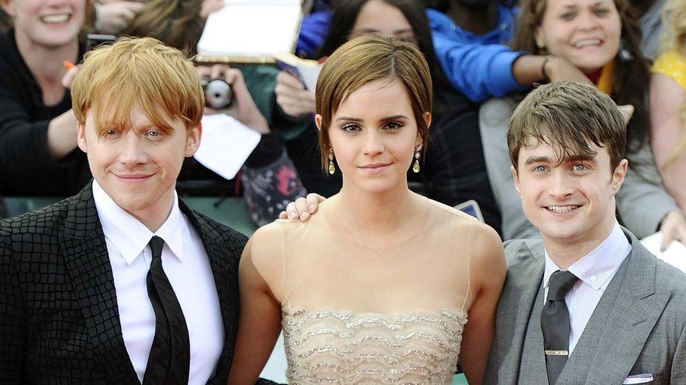 Emma Watson (C) poses together with fellow cast members Daniel Radcliffe and Rupert Grint (L)