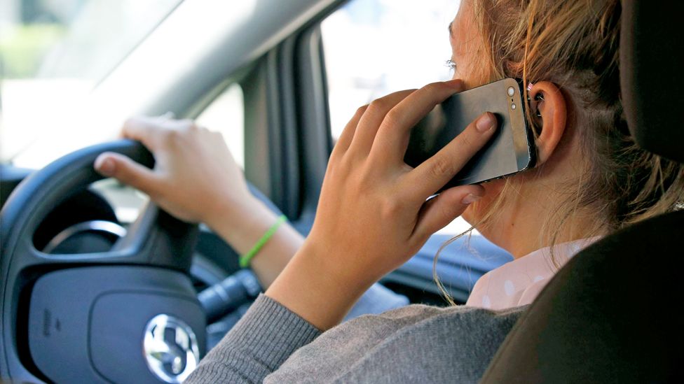 Woman driving while on a mobile phone