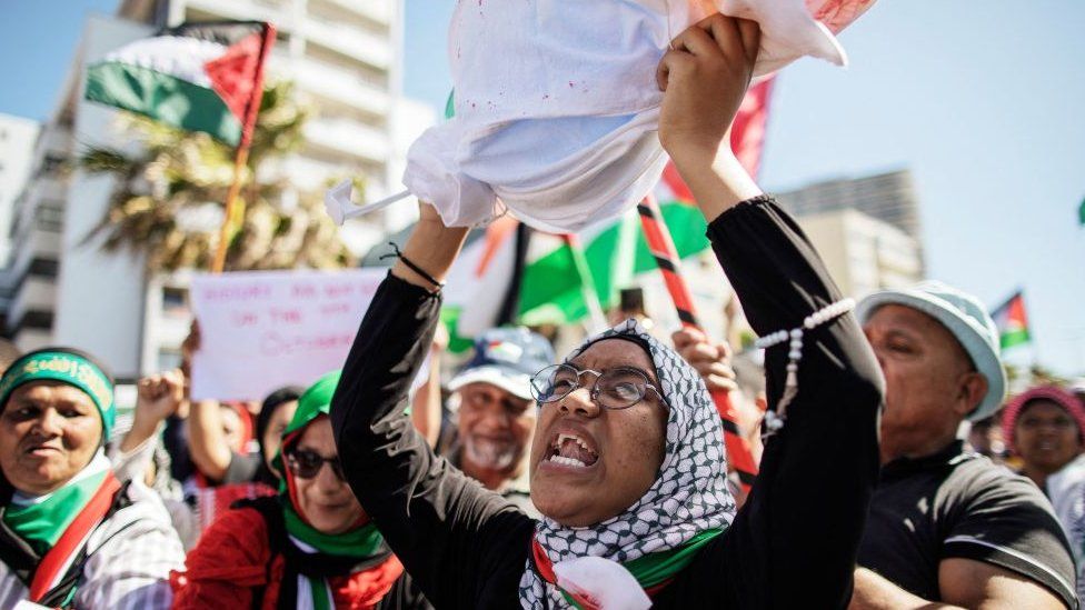 A woman raises a mock body bag as pro-Palestinian supporters shout anti-Israeli slogans in Cape Town on November 12, 2023,