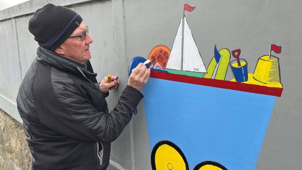 Retired teacher Chris Cowie painting a mural to cover graffiti tags in Edinburgh