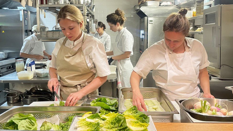 Manon Fleury in her restaurant alongside team members preparing food
