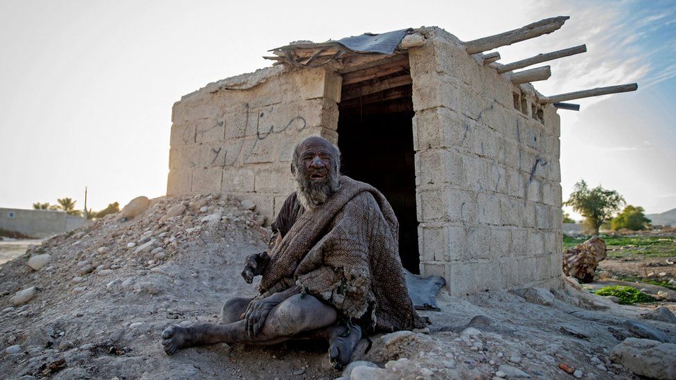 Amou Haji (uncle Haji) sits in front of an open brick shack that the villagers constructed for him, on the outskirts of the village of Dezhgah in the Dehram district of the southwestern Iranian Fars province, on December 28, 2018.