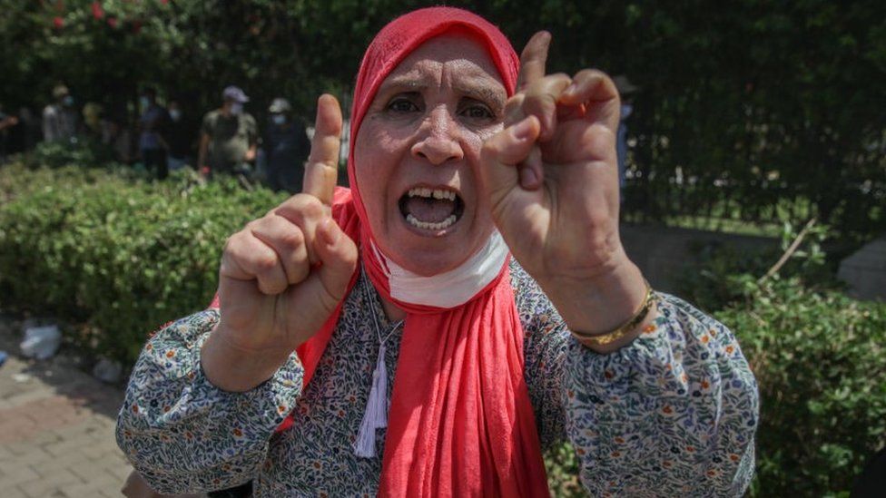 Женщина-сторонница исламистской партии Ennahdha жестикулирует во время сидячей акции протеста, проводимой спикером тунисского парламента Рашедом Ганнуши, перед зданием тунисского парламента в Бардо в столице Туниса, Тунис, 26 июля. , 2021
