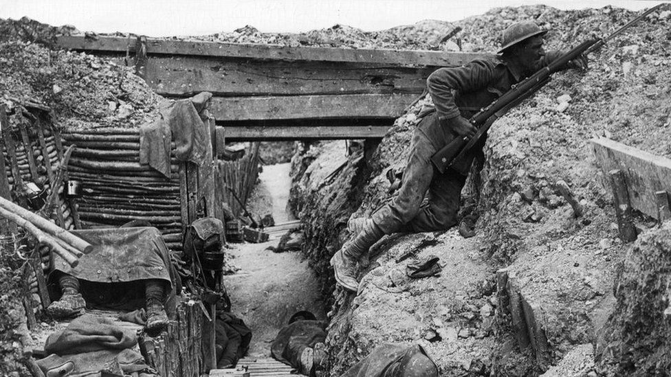 A British soldier looks out over the front line from a trench