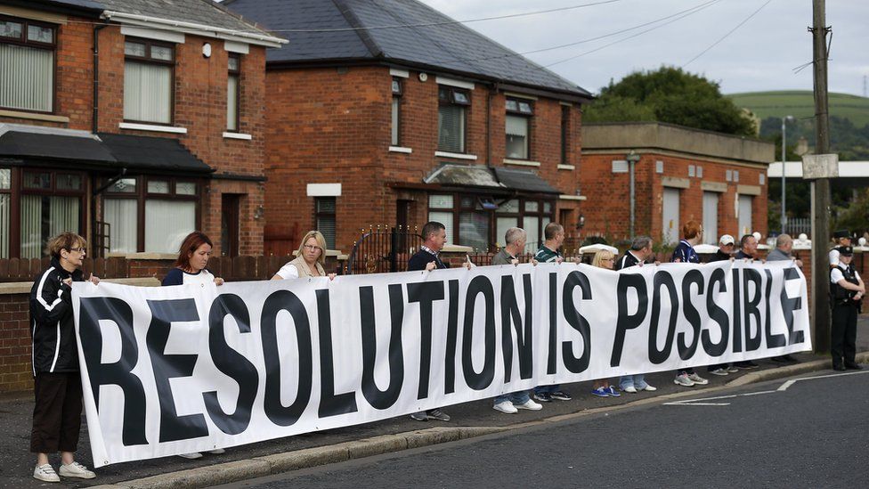 Nationalist residents hold a banner that reads: 'Resolution is possible'