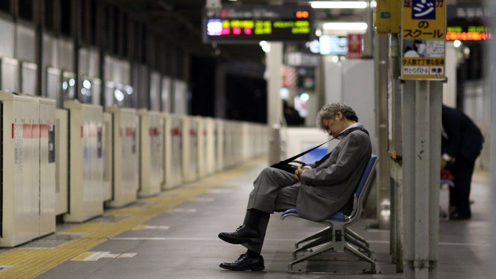 A businessman sleeps on a bench at a Tokyo train station