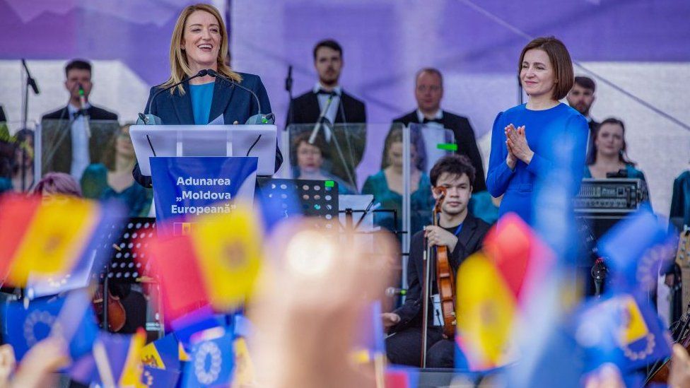 Председатель Европейского парламента Роберта Метсола (в центре) обращается к народу, а президент Молдовы Майя Санду (в центре) слушает во время митинга в поддержку ЕС в Кишиневе 21 мая 2023 года. Встреча
