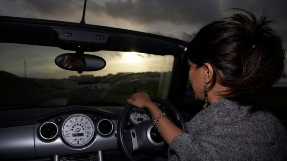 A woman driving at night