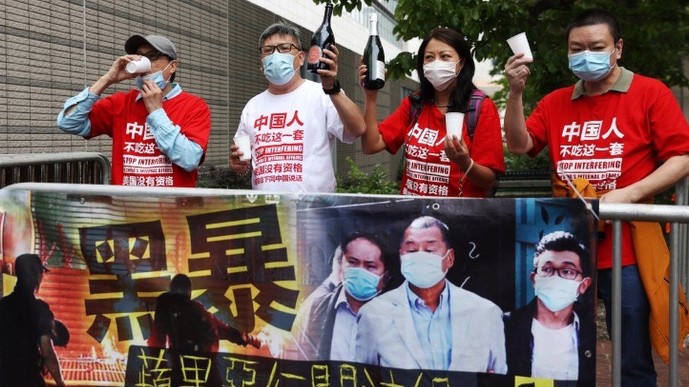 Pro-Beijing demonstrators celebrate the sentences