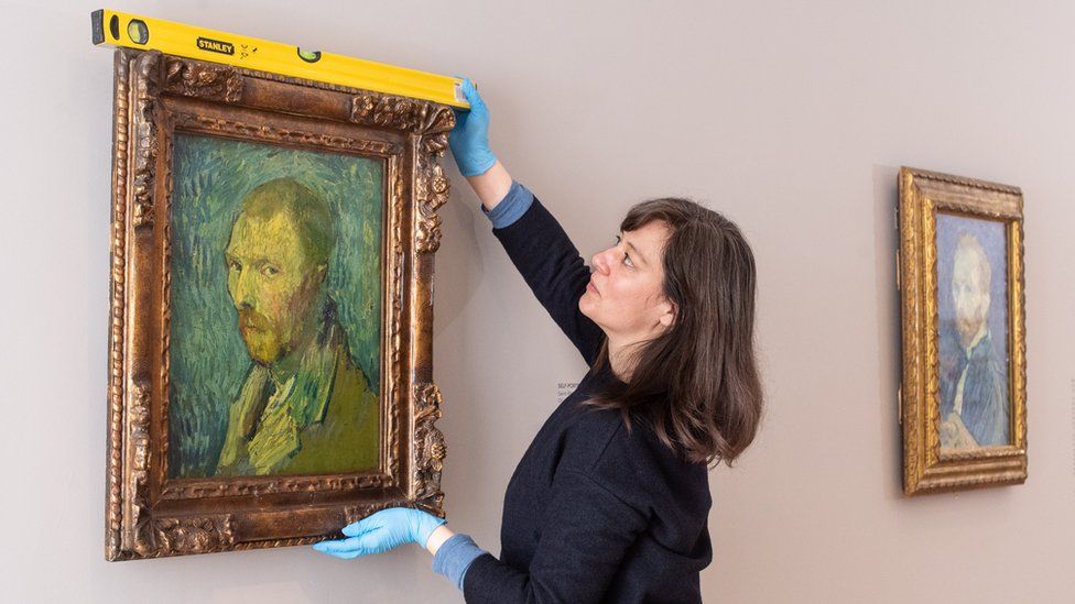 A gallery worker measures a self portrait by Vincent van Gogh