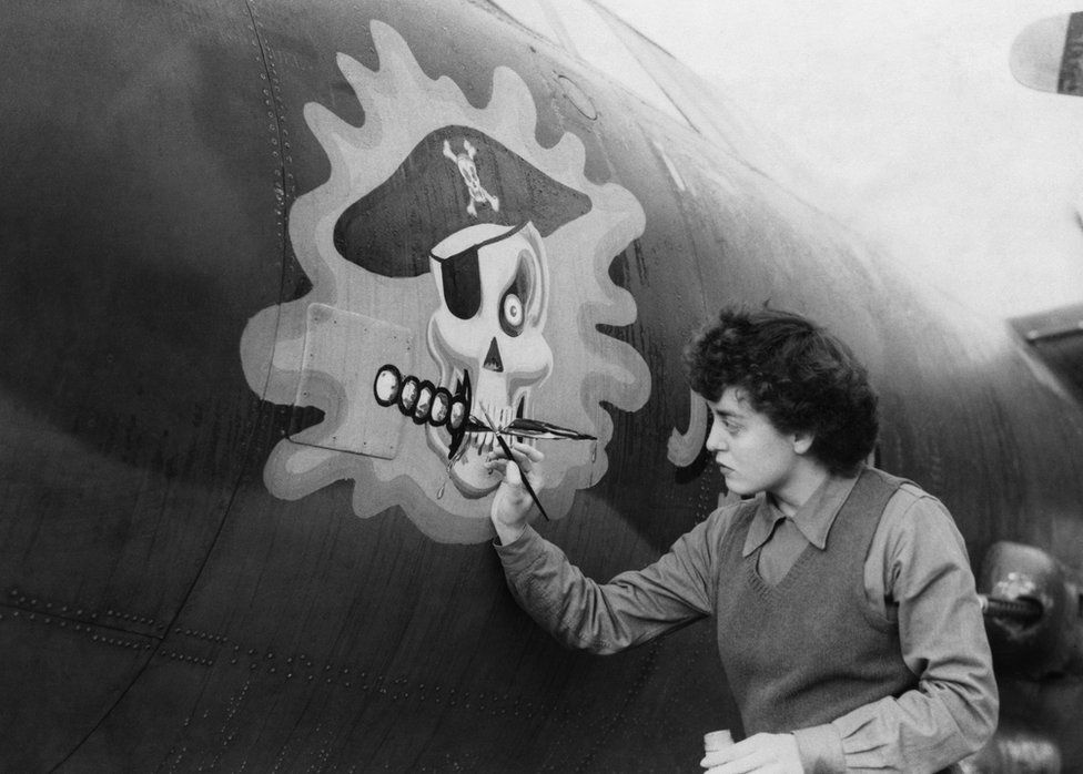 Private First Class Barbara O'Brien applies the finishing touches to a skull on the nose of a B-26 Marauder