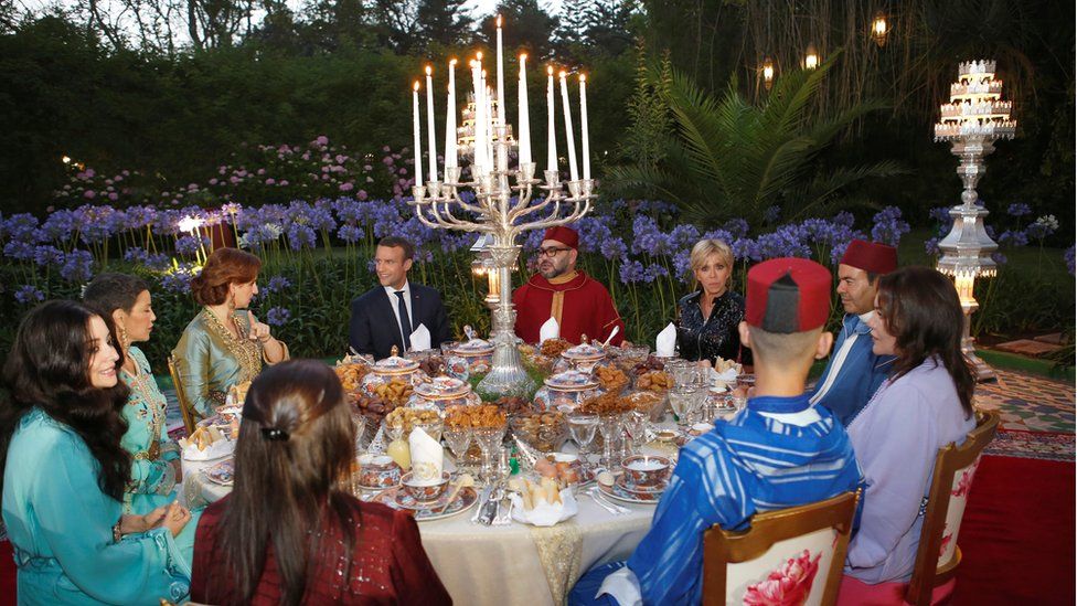 Morocco"s King Mohammed VI (CR), his wife Princess Lalla Salma (background L), France"s President Emmanuel Macron (CL) and his wife Brigitte Trogneux (background R), attend an Iftar meal, the evening meal when Muslims end their daily Ramadan fast at sunset, at the King Palace in Rabat, Morocco, June 14, 2017