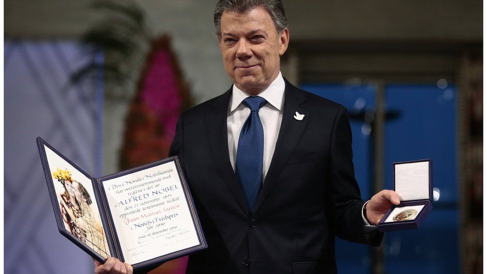 Nobel Peace Prize Laureate Colombian President Juan Manuel Santos poses with the medal and diploma during the Peace Prize awarding ceremony at the City Hall in Oslo on Saturday Dec. 10, 2016