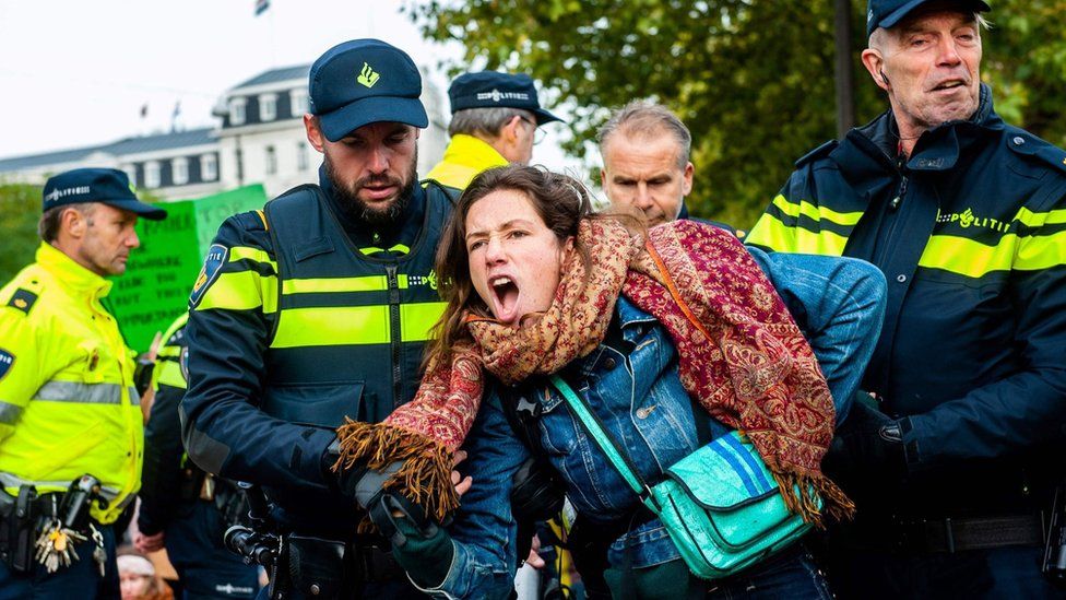 A woman is arrested by police at a protest in Amsterdam