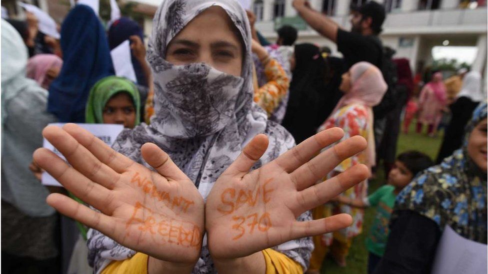 A Kashmiri woman shows her henna-painted hands with the slogans We Want Freedom and Save 370 during a protest, at Soura, on August 16, 2019 in Srinagar, India.