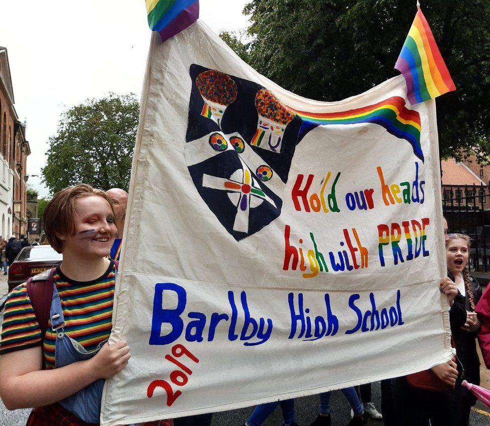 Students holding a homemade Pride banner