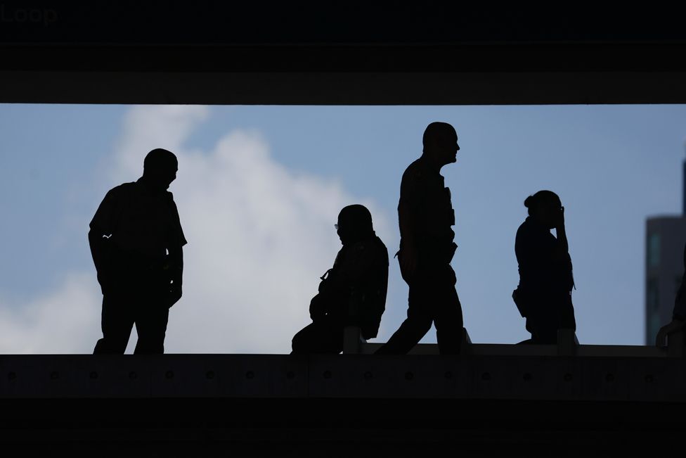 Law enforcement officials stand guard at a transit stop outside of the Wilkie D. Ferguson Jr. federal courthouse on June 13, 2023 in Miami, Florida